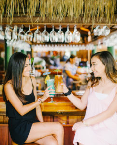 Two girls enjoying their tropical drinks at the bar