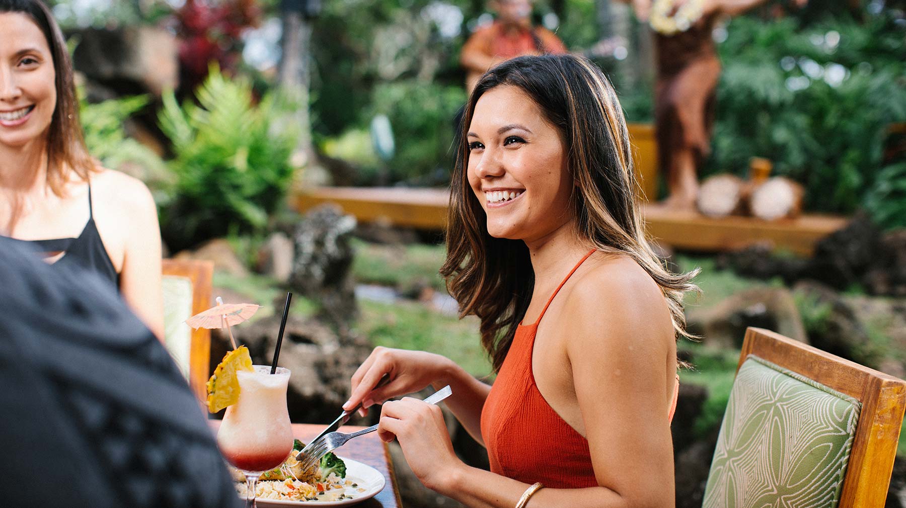 Women enjoying her meal with a tropical drink