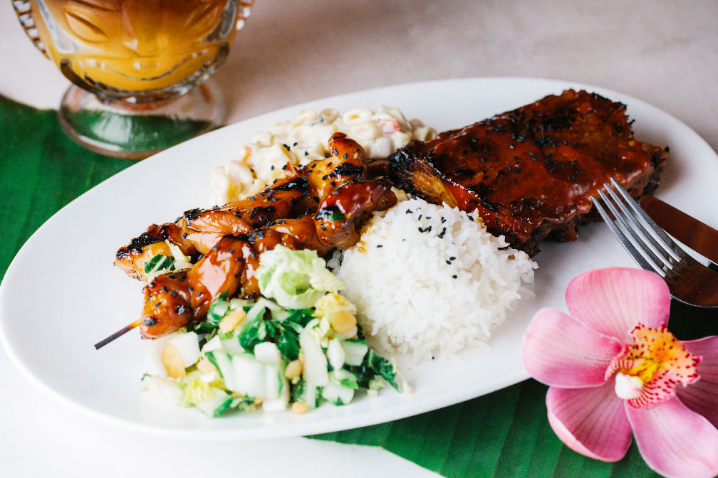 photo of a lunch plate with chicken, rice, a cocktail, and a flower